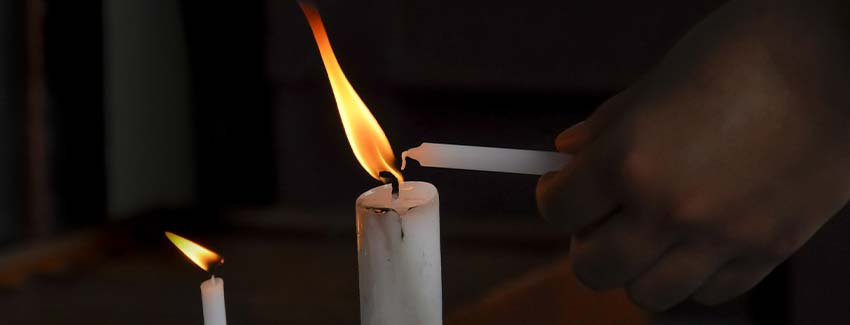 Candles being little by someone in a dark room