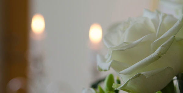 White roses with candles lit in background