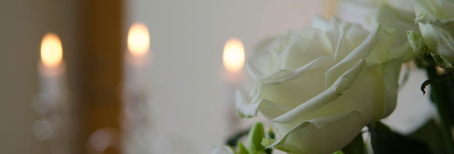 White roses with candles lit in background
