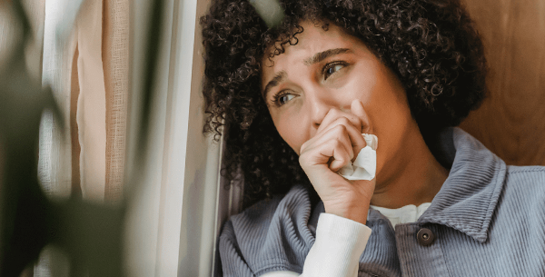 Person leaning against wall in grief