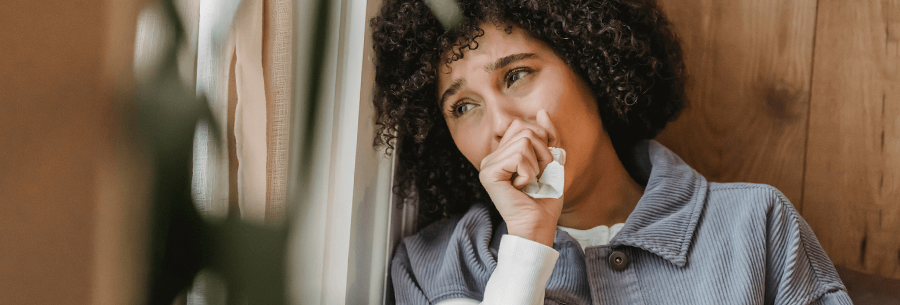 Person leaning against wall in grief